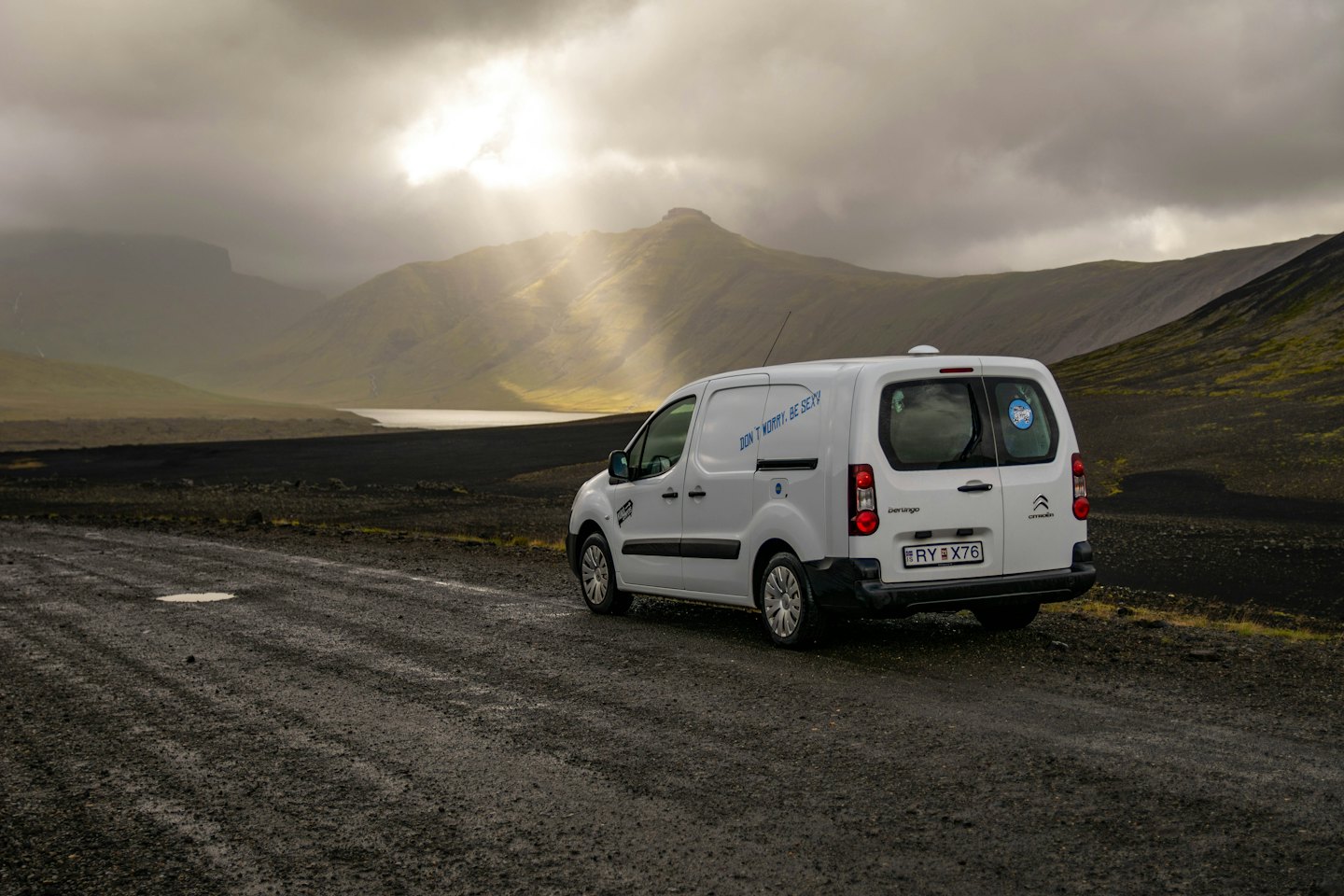 White cargo van parked on a remote gravel road.