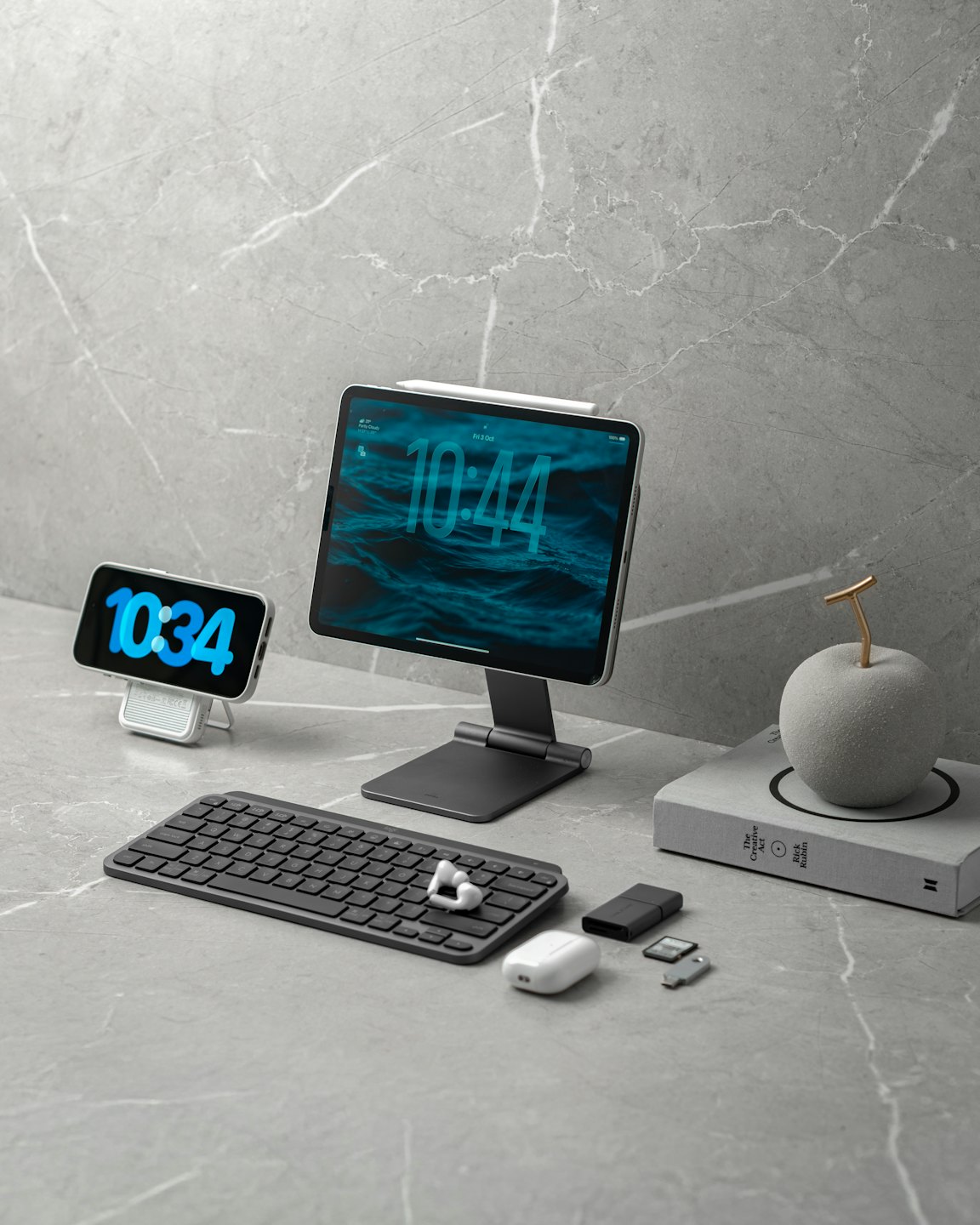 Digital devices and office accessories arranged on a marble surface.